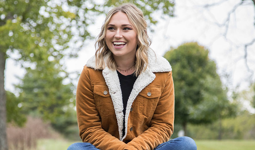 Young WPCU member sitting on a picnic table in a park
