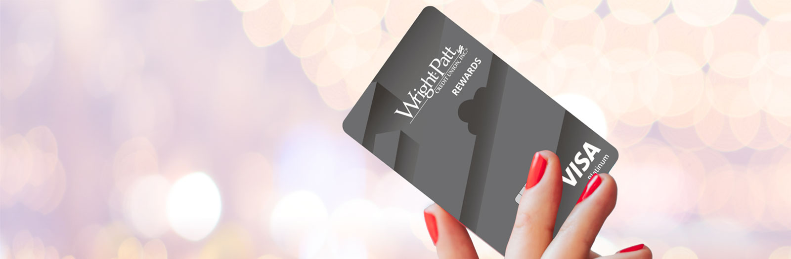 Woman's hand with red nail polish holding WPCU Rewards Visa Credit Card