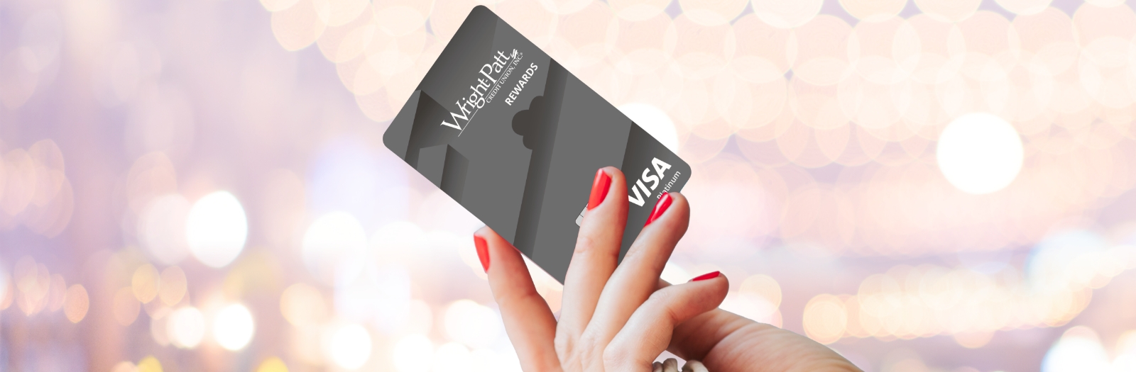 Woman's hand with red nail polish holding WPCU Rewards Visa Credit Card