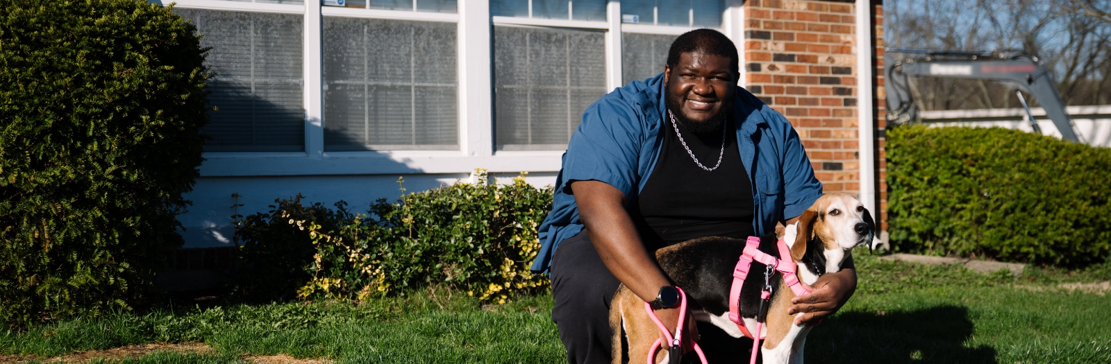 Image of WPCU Member Ja'Saun J. and his dog in front of a house