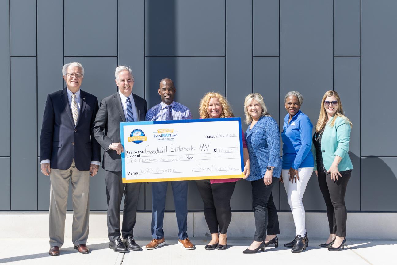 Staff members holding a giant check